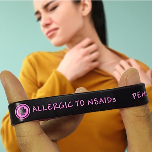Black Rubber Bracelet That Says Allergic To NSAIDS in Pink Ink