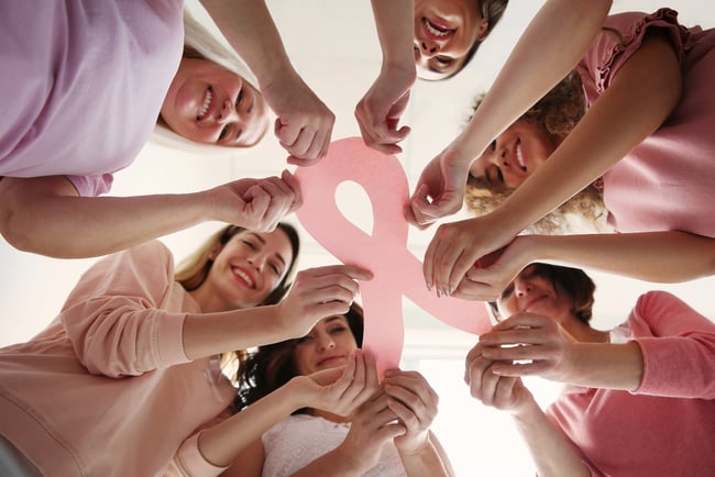 Image of a group of breast cancer survivors holding a pink ribbon