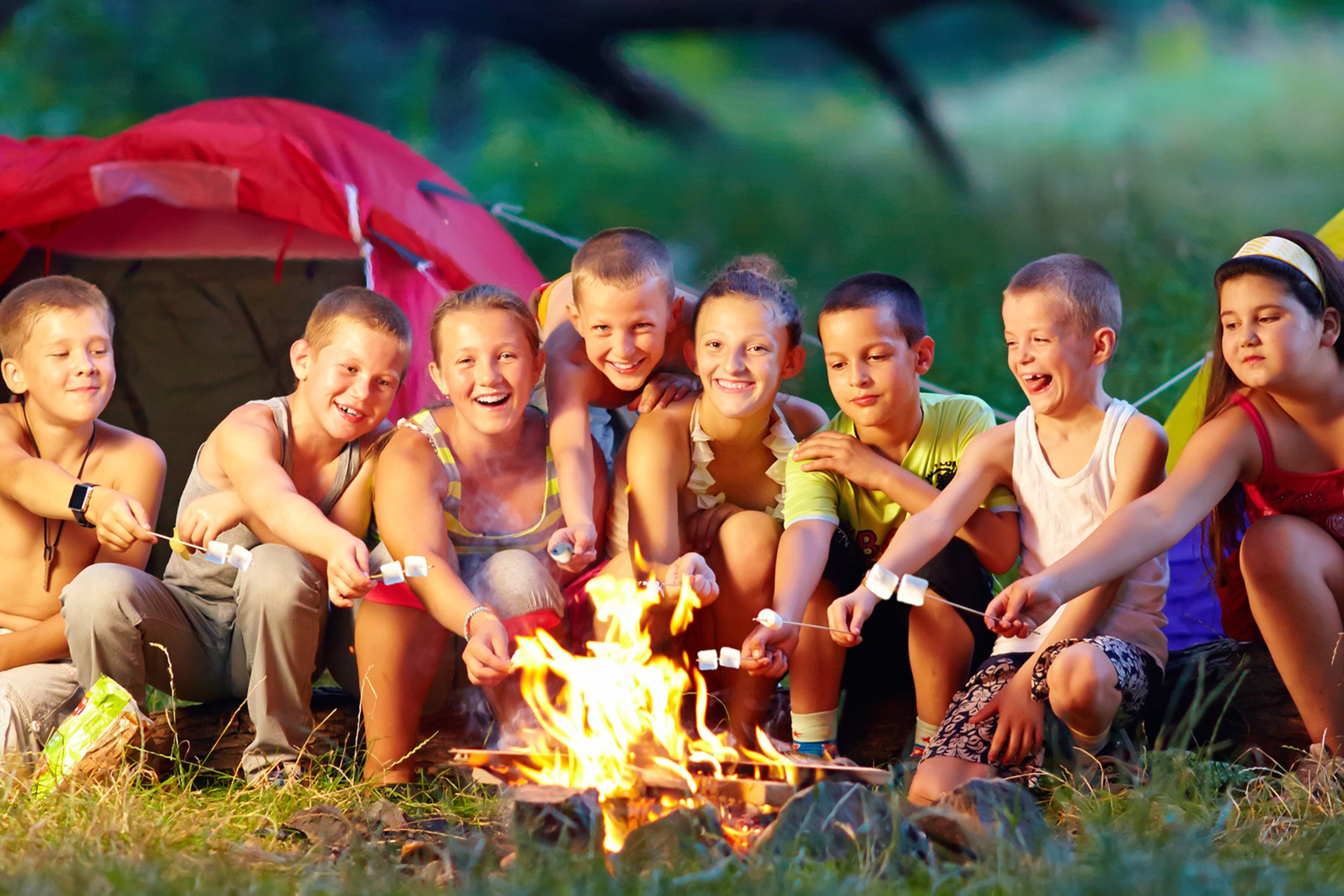 Campers making s'mores around a campfire