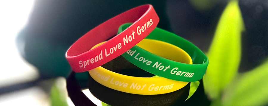 Red. Green, and Yellow wristbands that read "Spread Love Not Germs"