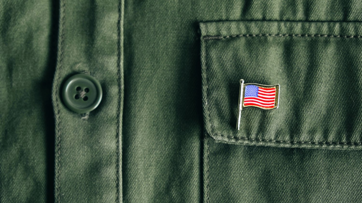 Photo of a military style shirt with an American flag lapel pin
