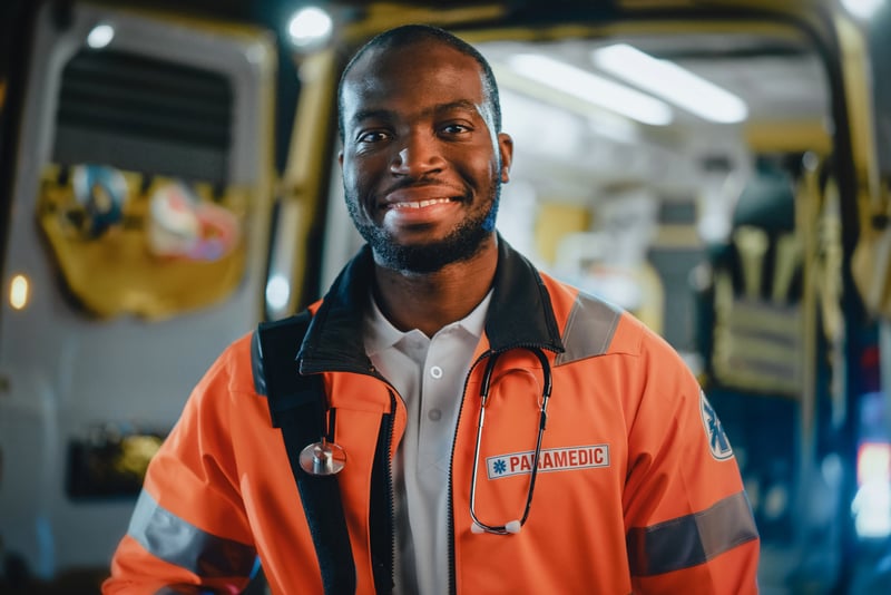 Image of a paramedic in uniform in front of an open ambulance