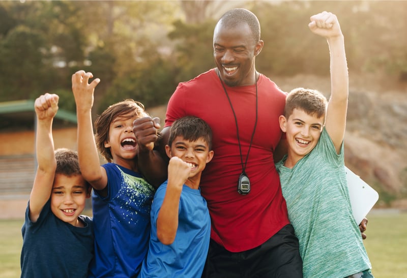 Image of a coach and his athletes for National Coaches Day