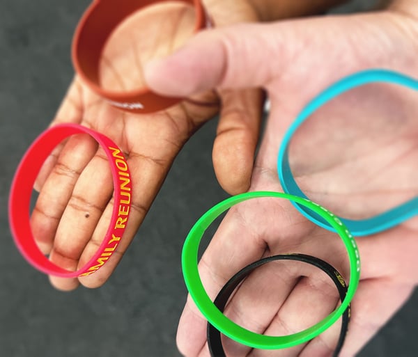 Photo of family members holding customized wristbands as low-cost reunion favors