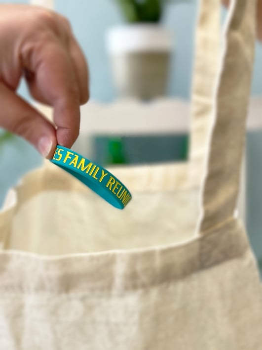 Photo of personalized engraved wristband items being used as family reunion gifts that could be placed in personal tote bags