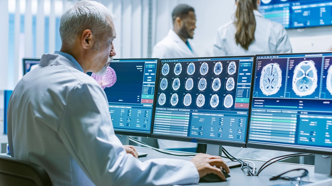 Scientist Monitoring Multiple Brain Scans