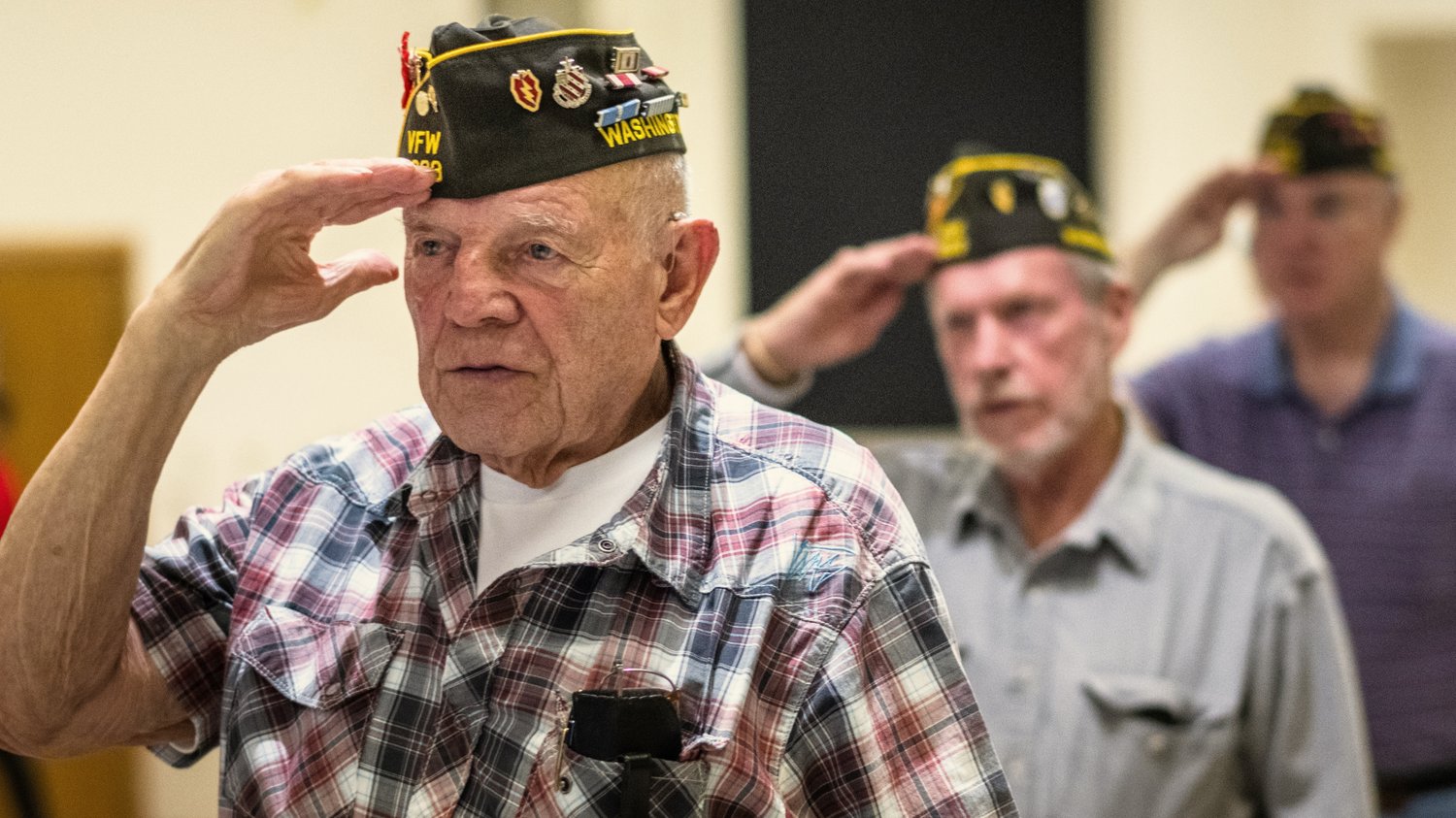 Photo of three military veterans saluting