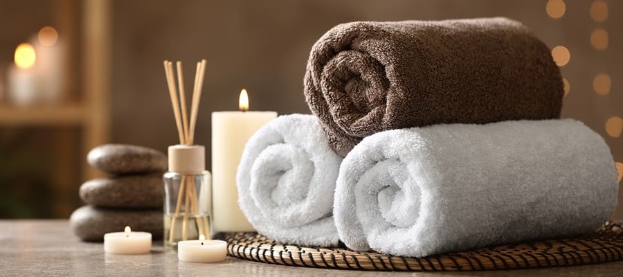 Towels, hot stones, and candles at a spa or massage parlor.