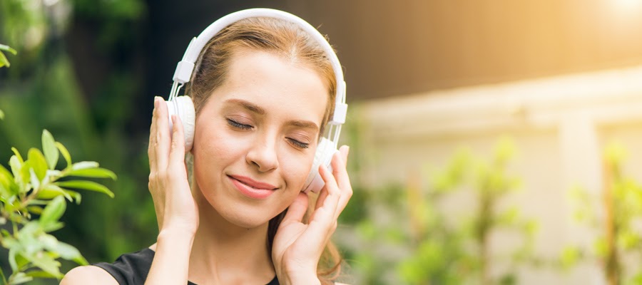 A happy woman listening to music on hearphones