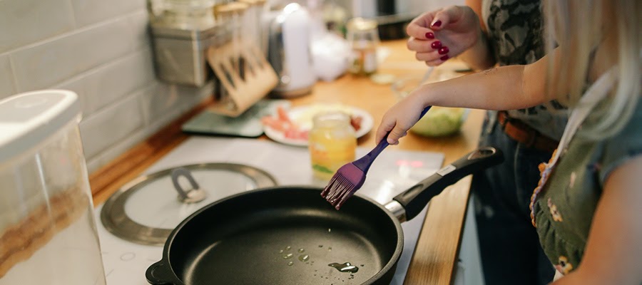 A mother and her young daughter cooking together