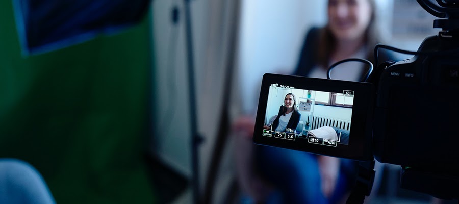 A woman making a video while sitting on her couch