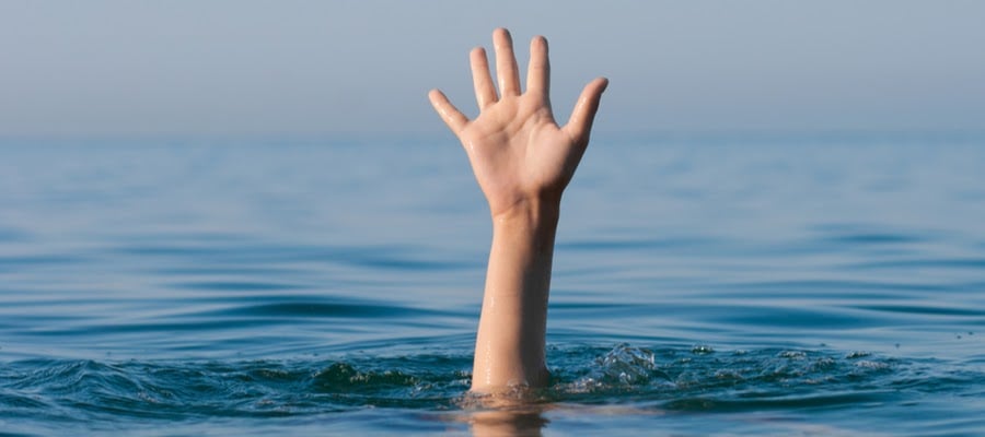 A drowning man waves his hand for help